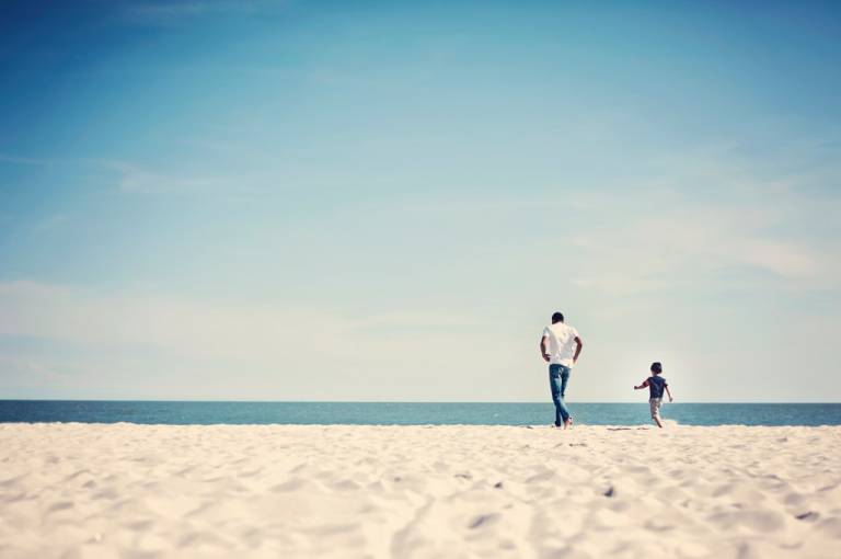 Father and son running on the beach