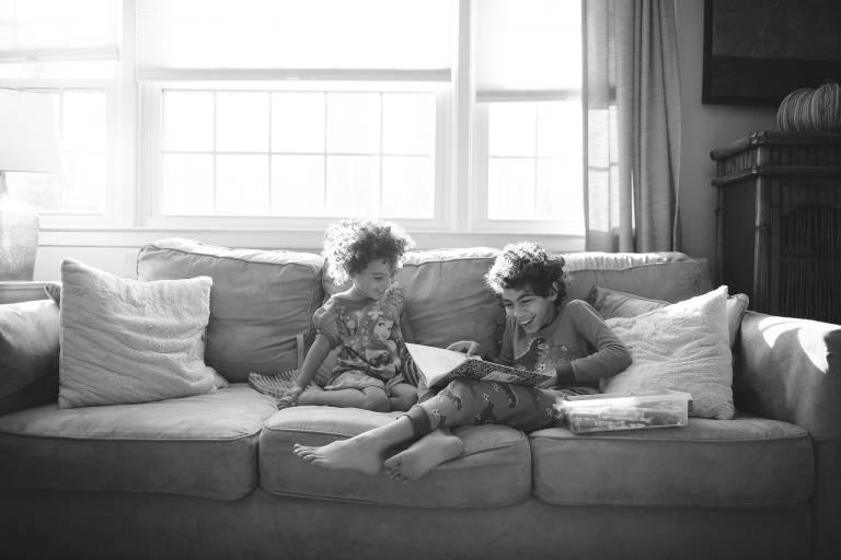 Siblings laughing on couch
