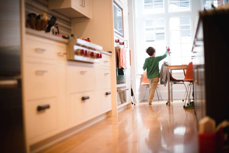 Boy playing with plane in kitchen