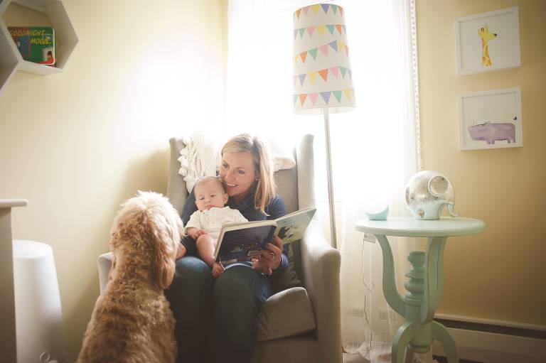 Mother, son, and dog reading in nursery