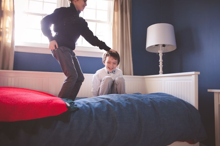 Brothers jumping on bed together