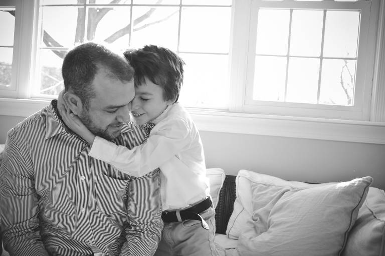Father and son snuggling on couch