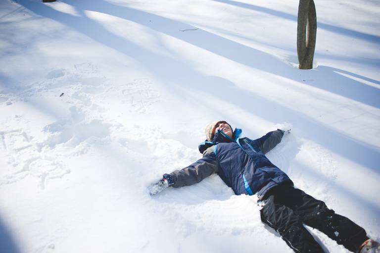 Boy making snow angels 