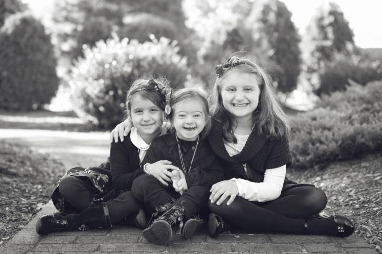 Down syndrome child with her sisters