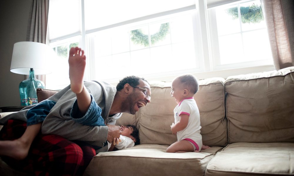 Father and kids playing on the sofa